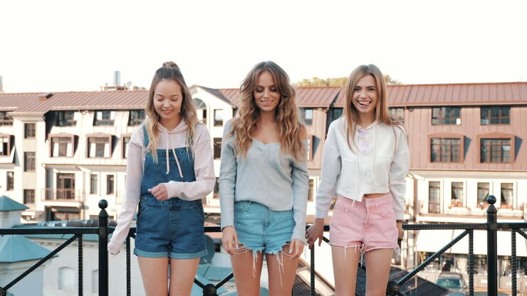 Tre giovani donne felici che si divertono su un tetto
