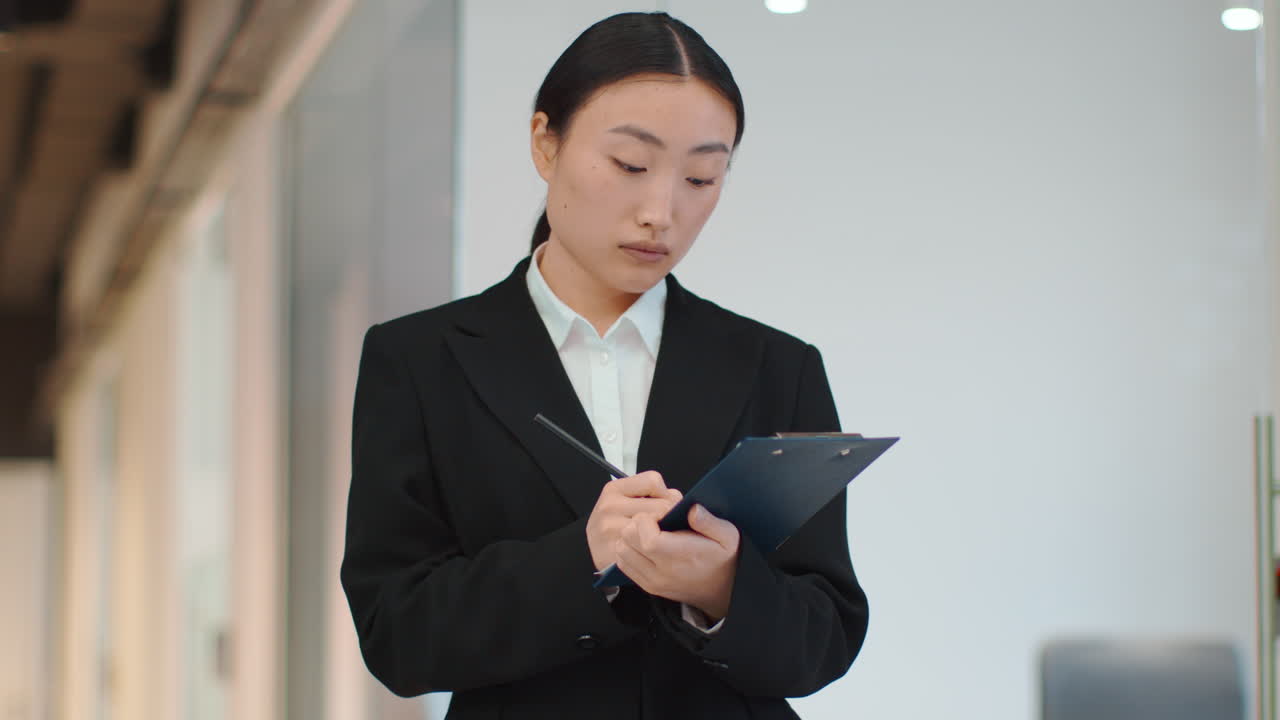 mujer de negocios tomando notas en una oficina moderna