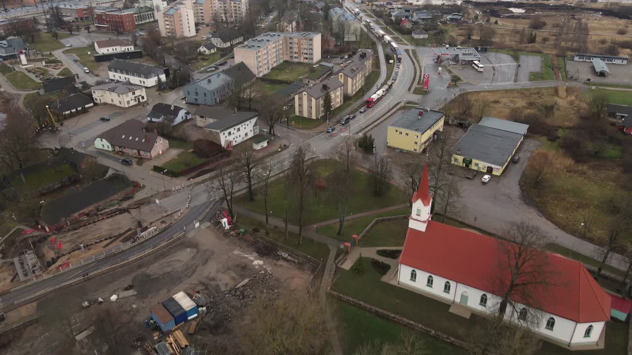 Aerial photograph of Salacgrīva, a coastal city in Latvia, featuring residential buildings, industrial areas, and a riverbank. Ideal for urban or geographical studies.