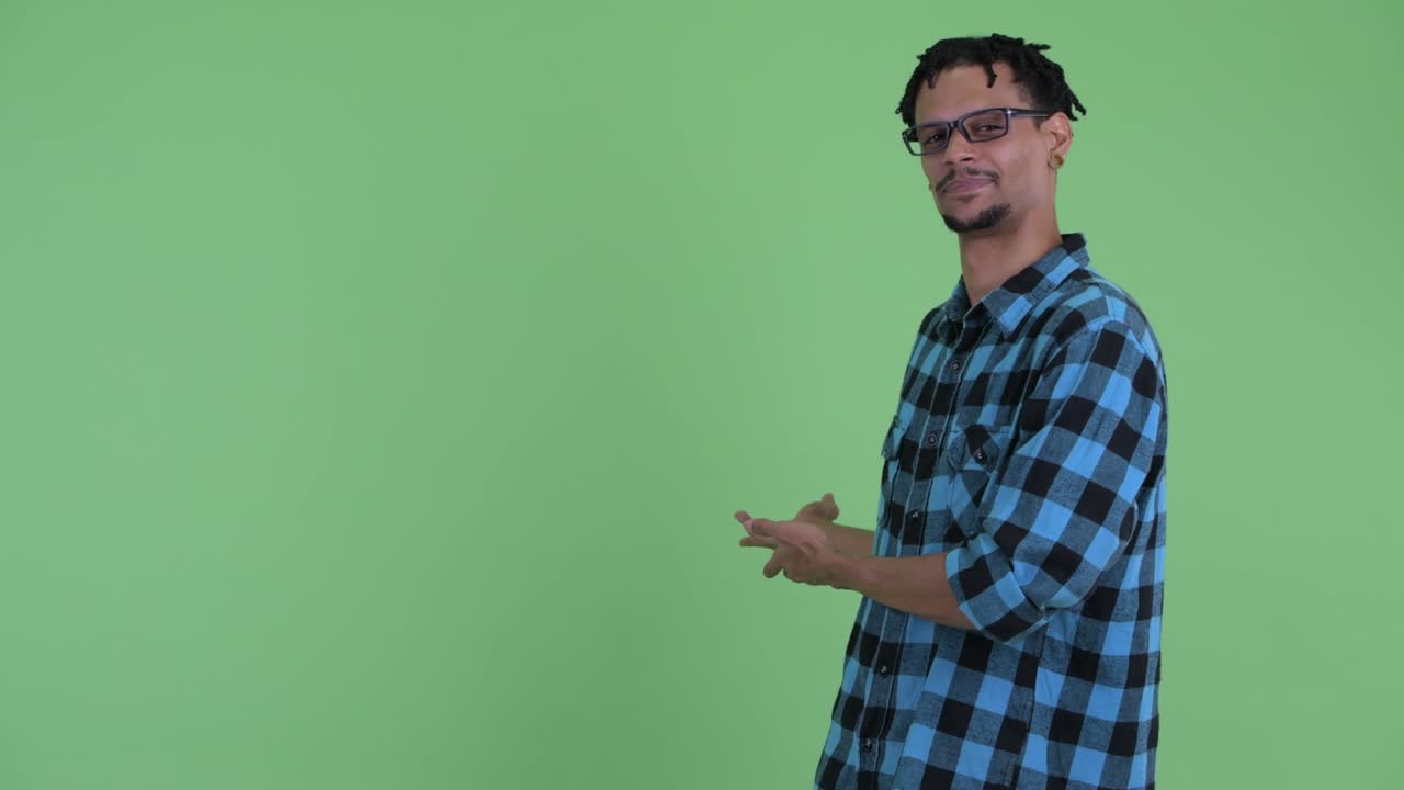 joven feliz y guapo hombre hipster africano mostrando algo