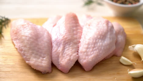 fresh raw middle chicken wings on wooden board with ingredients