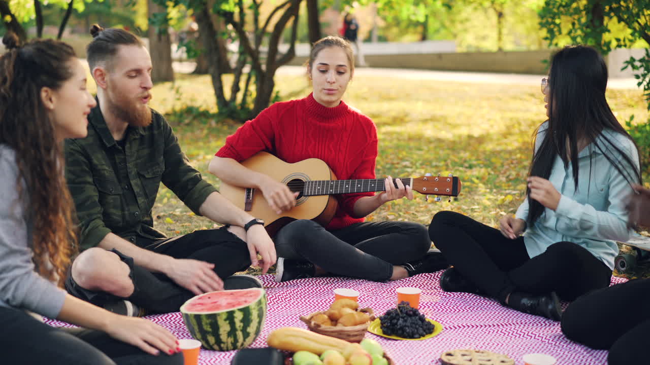 친구 들 이 공원 에서 피크닉 을 즐기고 있다