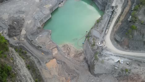 Flyaway-shot-of-a-rock-quarry,-displaying-a-beautiful-sunset-sky