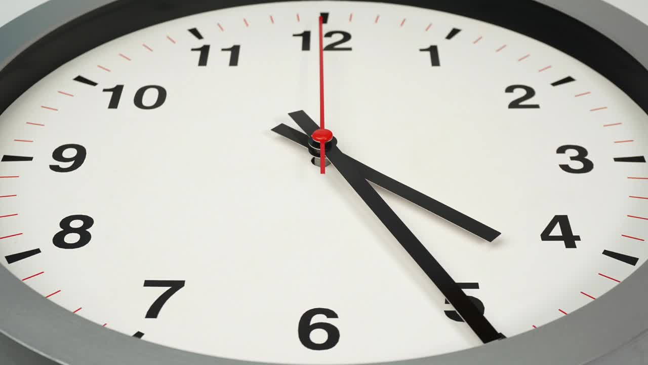 Time lapse grey wall clock show the time at 5 o'clock.