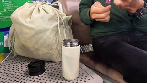 person mixes a drink in a tumbler on a train