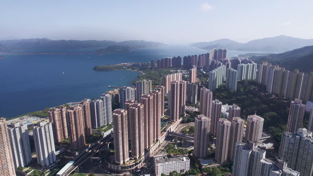 hermosos rascacielos de varios colores construidos uno al lado del otro entre la naturaleza verde y el mar azul en hongkong