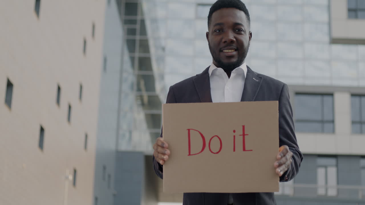Man Holding a Cardboard Sign Saying 'Do It'