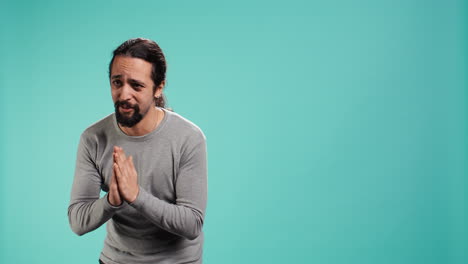 hombre juntando las manos en un gesto de mendicidad, pidiendo un favor