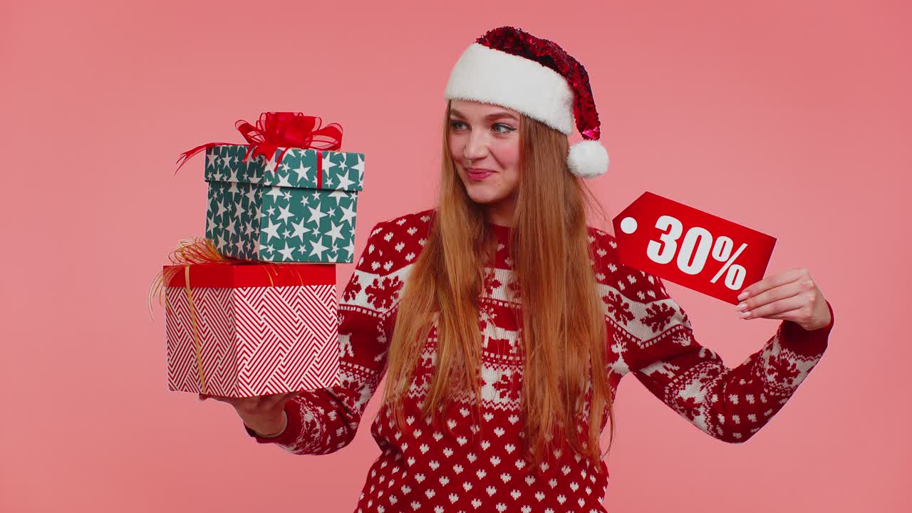 niña con suéter de navidad mostrando cajas de regalos y inscripciones de descuento del 30 por ciento nota de texto de banner