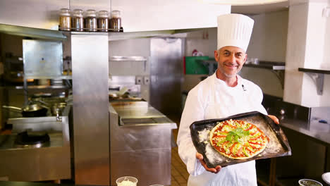 el chef rociando albahaca en una pizza