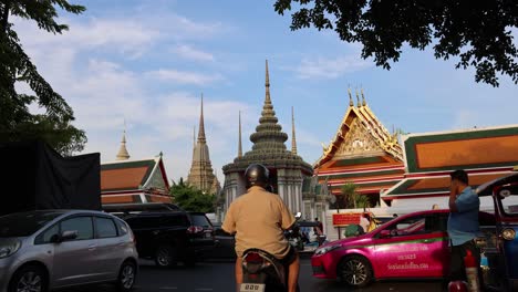 pedestrians and vehicles moving by a temple