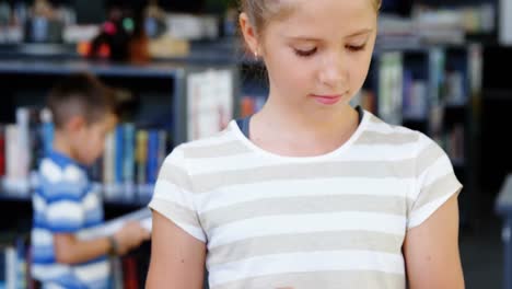 schoolgirl reading book in library