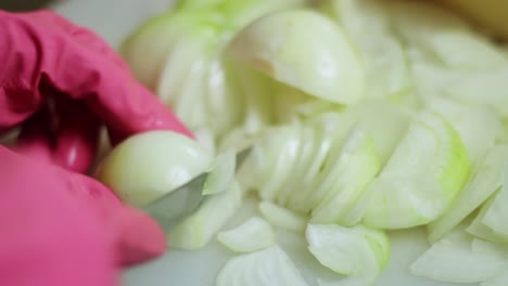 라텍스 장갑 근접 촬영을 입고 신선한 양파를 자르기