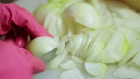 chopping fresh onions wearing latex gloves closeup