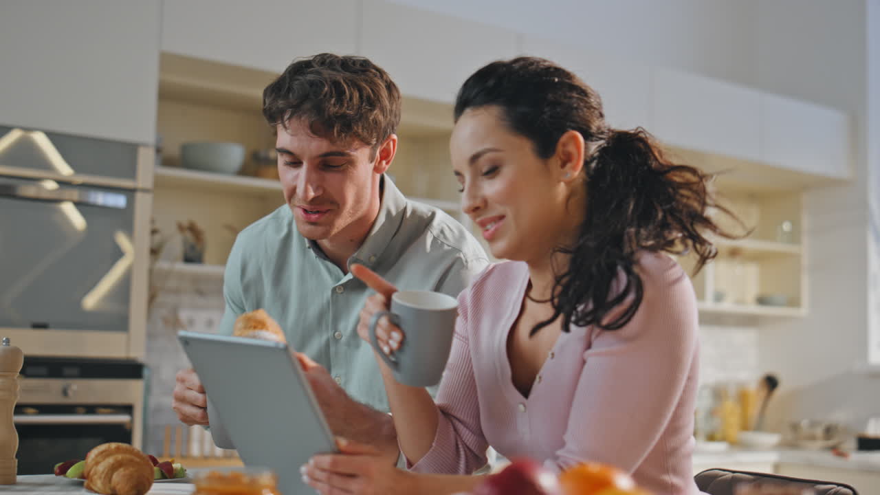 pareja romántica comprando en línea en el desayuno familiar de cerca. pareja usando gadget