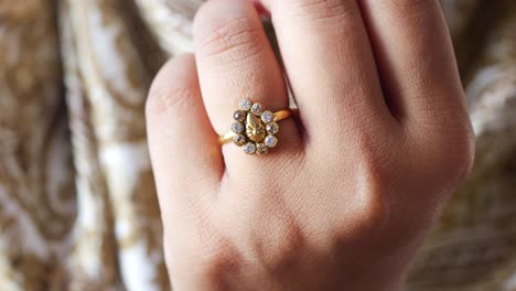 anillo de oro con diamantes en la mano de una mujer