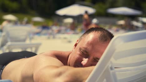 close-up man is lying on sun lounger on the beach athletic physique