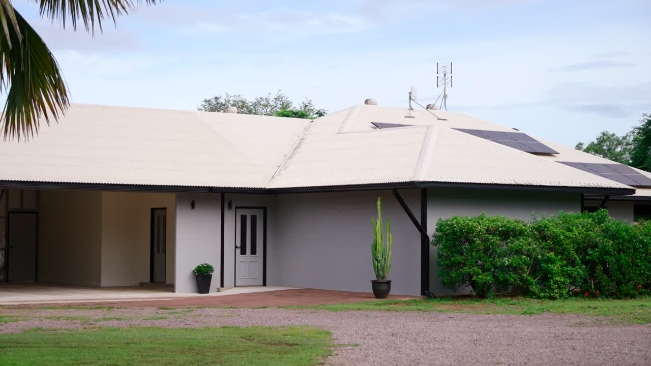 pan a través de la fachada de una lujosa finca rural con garaje al aire libre y paneles solares