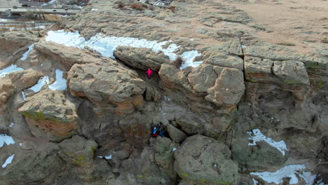 drone view of climbers going on top of a rocky mountain during the winter in colorado