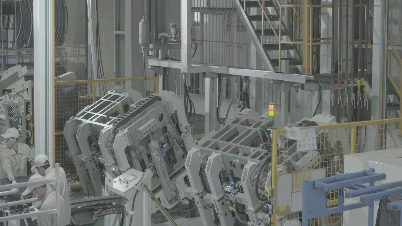 Industrial professional worker wearing uniform puts metal steel sheet component under press machine in factory to makes the parts cars in manufacturing vehicle industry plant.