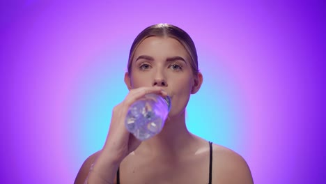 La-Mujer-Caucásica-Disfruta-De-Agua-Dulce-De-Una-Botella-De-Plástico,-Foto-De-Estudio