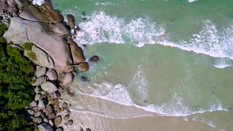 Von-Oben-Nach-Unten-Aufgenommene-Luftaufnahme-Von-Meereswellen,-Die-Den-Strand-In-Bombinhas,-Brasilien,-Erreichen