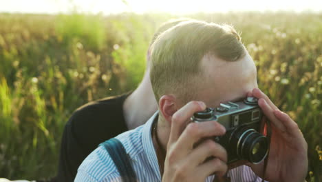 man die een vintage camera buiten gebruikt