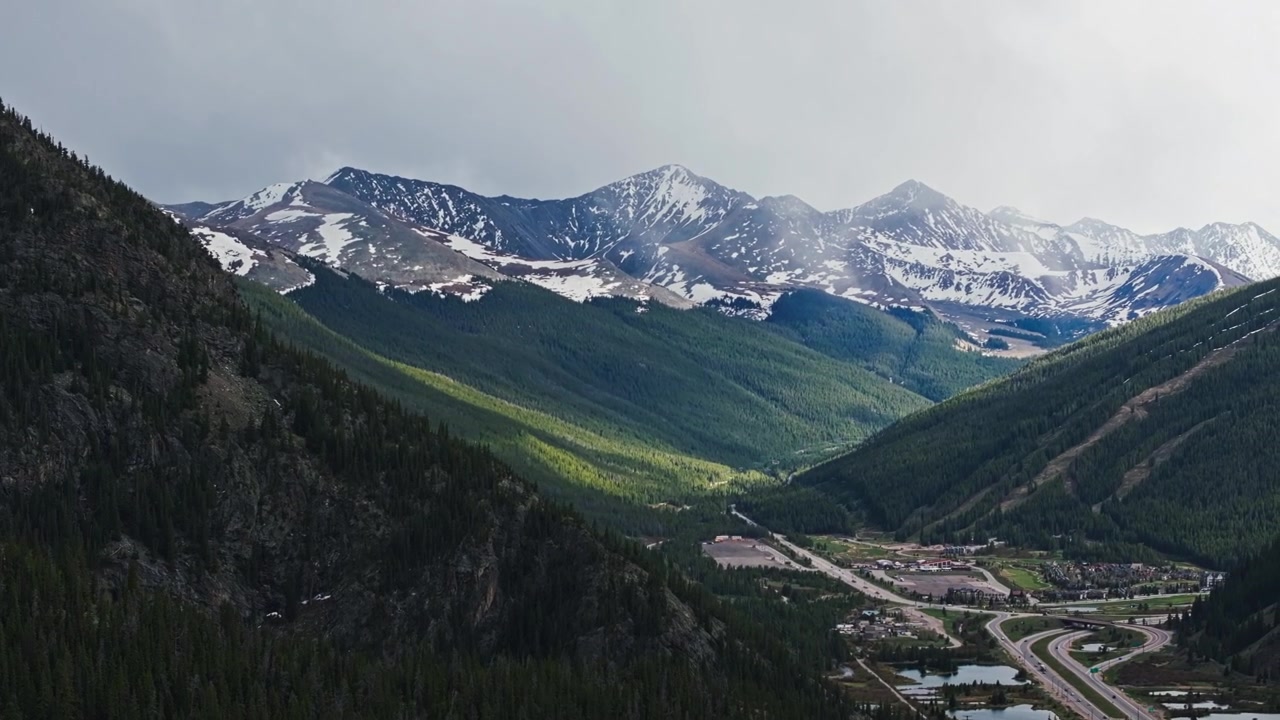 Cime alpine innevate sopra la valle di Frisco Gulch e il corridoio autostradale, panoramica del drone verso destra