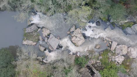 Aerial-descending-shot-over-water-rapids-in-a-river-of-Portugal-in-slow-motion