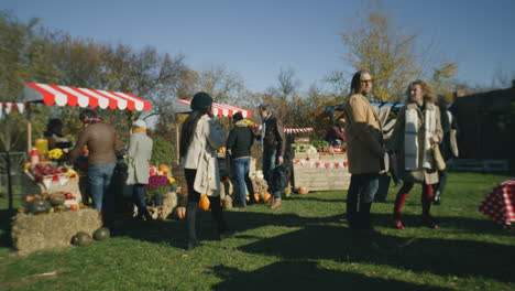 farmers market or autumn fair outdoors a lot of diverse people walking shopping choosing fruits and vegetables at local farmers market autumn fair on weekend outdoors vegetarian and organic food agriculture points of sale system