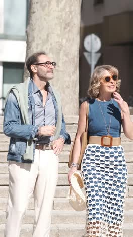 stylish mature friends walking down stairs on street. vertical footage