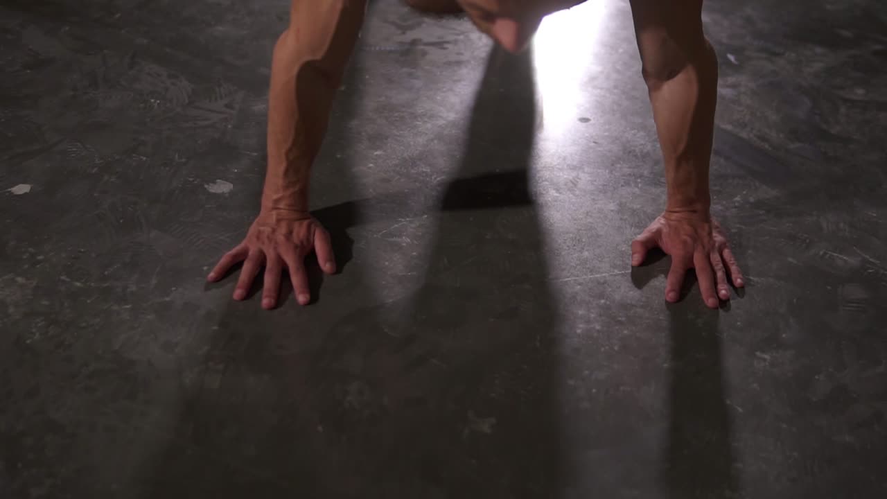 Adult muscular male working out doing pushups. Good looking model man with dreadlocks exercising. Footage from the top of man's back muscules. Concept of wellbeing, calisthenics, aerobics, healthy lifestyle, wellness
