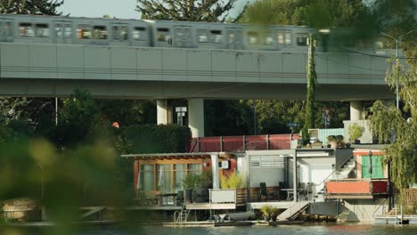 U-Bahn-Fährt-über-Brücke-Am-Ufergrundstück-In-Wien-Alte-Donau-Vorbei