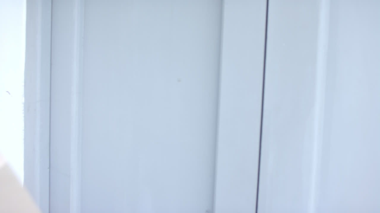 una mujer biracial feliz recibiendo un paquete en casa, en cámara lenta.