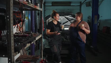 women mechanics discussing car repair in a garage