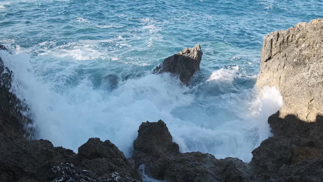 rocas irregulares sobresalen de las olas azules del océano que se estrellan
