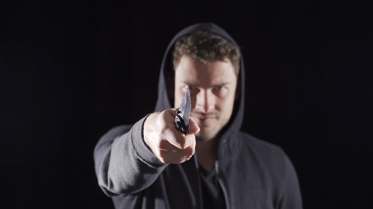 hombre vagabundo agresivo tiene un cuchillo en la mano.