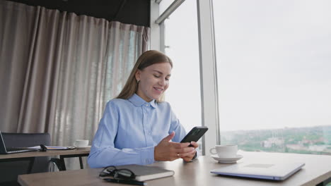mujer en la oficina usando un teléfono inteligente