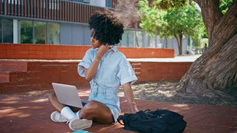 girl taking earphones sitting sunny park with laptop on knees close up.