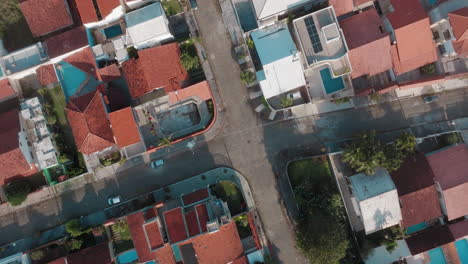 aerial top-down view of a residential neighborhood with red roofs and streets