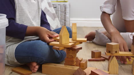 mother and son playing with building blocks in bedroom