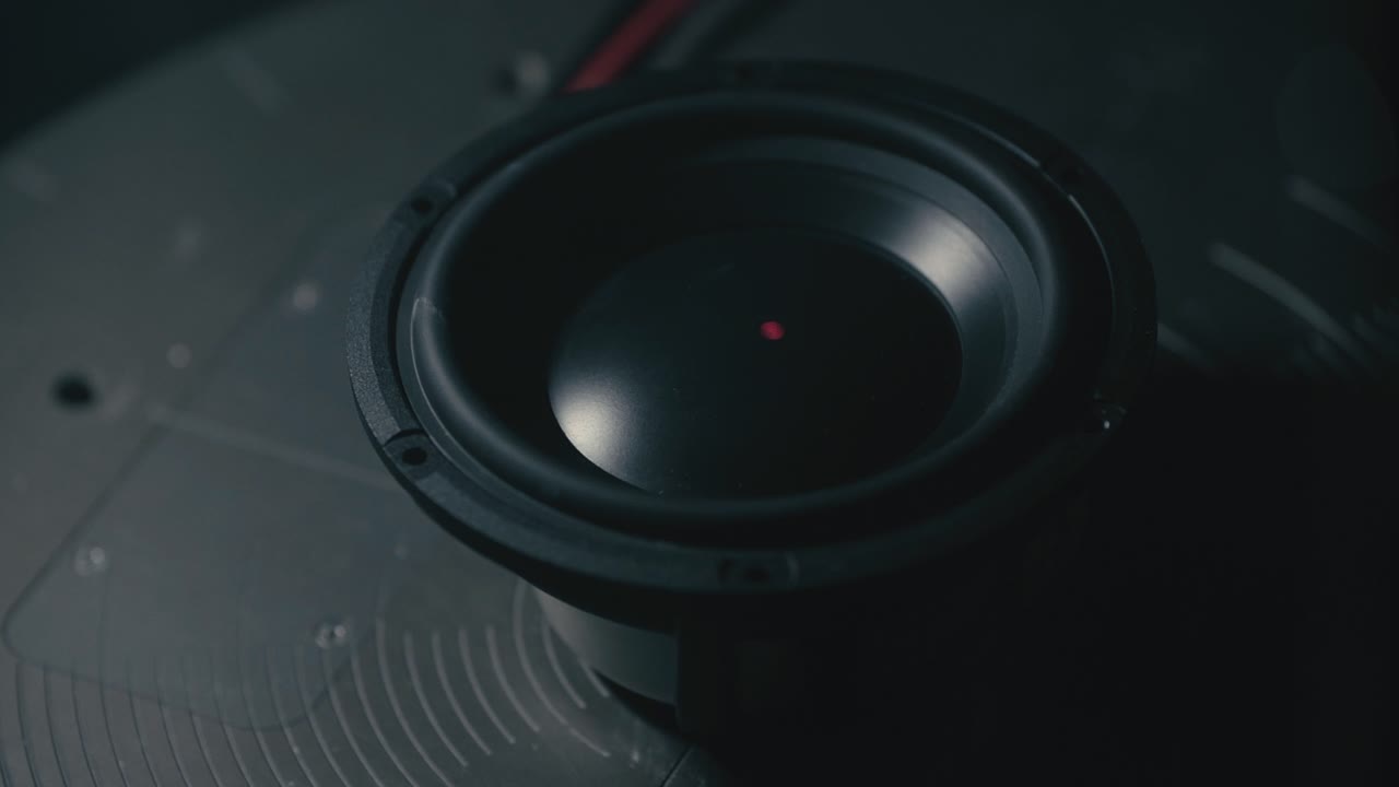Top down of Speaker tested with precision laser, visible light beam through smoke, vibration analysis, modern acoustic engineering
