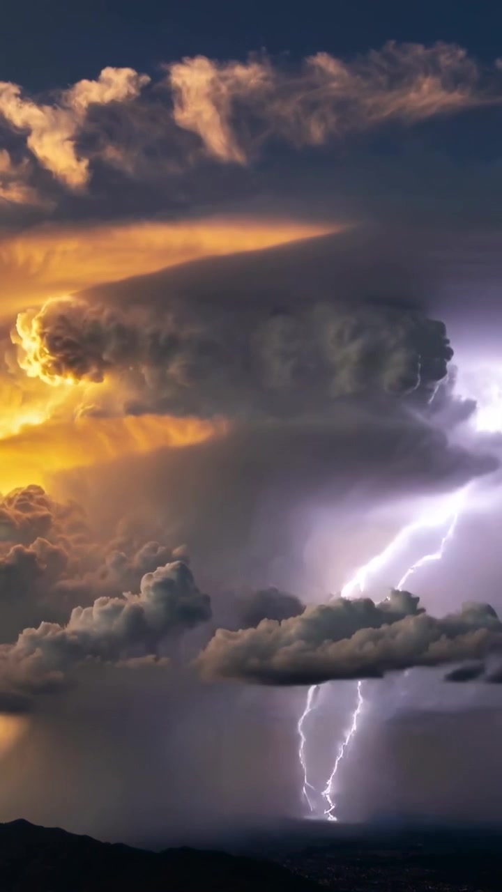 Video verticale: Mostra una nuvola temporalesca che genera fulmini sul fianco destro sopra una cresta, lato sinistro illuminato dal sole.