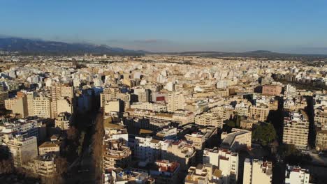 Drone-shot-of-Palma-De-Mallorca-with-hills-in-the-horizon