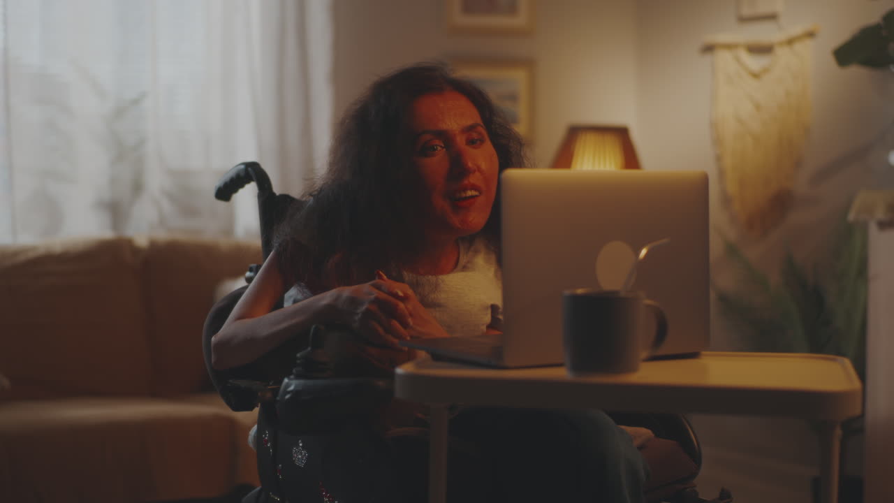 Senior Woman in Wheelchair Having Video Call with Doctor at Home
