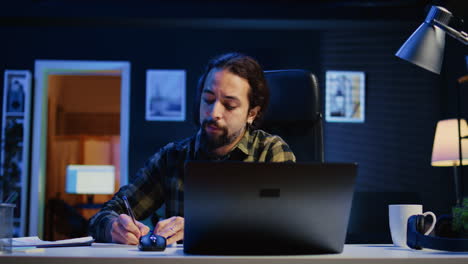 entrepreneur working at home office desk, writing in notebook