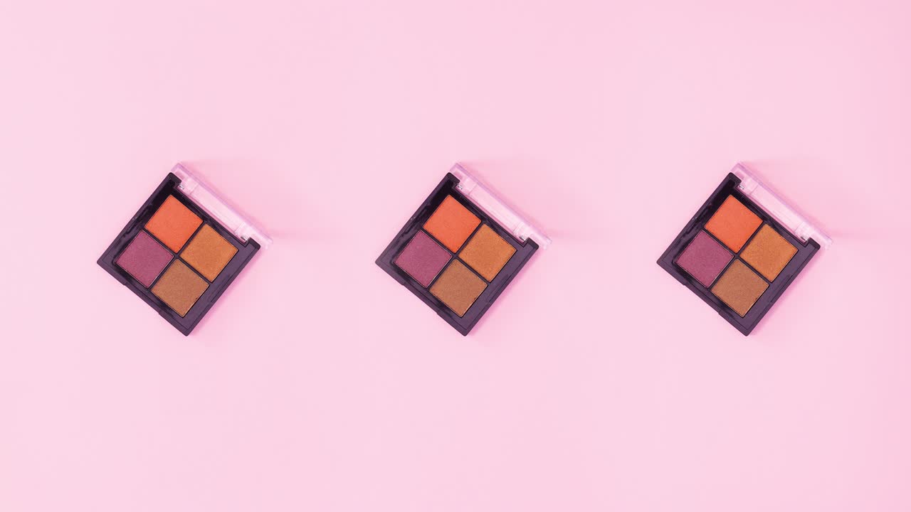Three eye shadow palettes with four colors rotating on bright pink theme. Stop motion