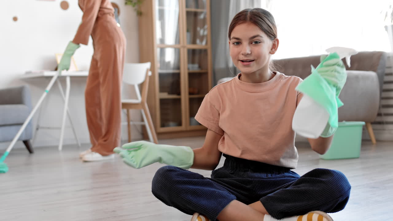 chica adolescente grabando un video mientras la mujer limpia el apartamento