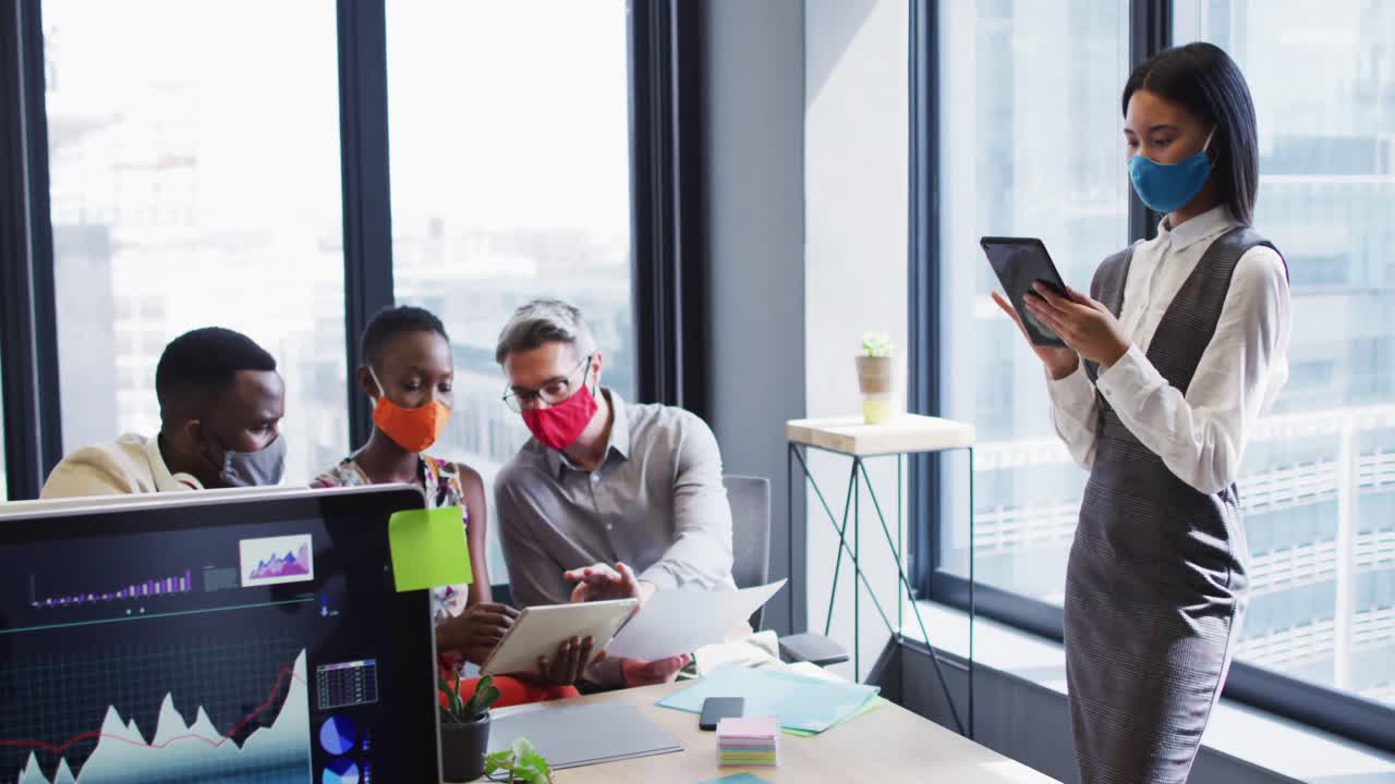 Asian woman wearing face mask using digital tablet at modern office