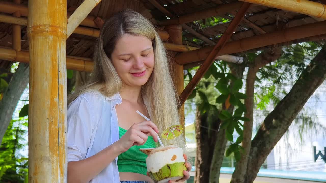 대나무 오두막 에서 코코 물 을 즐기는 여자